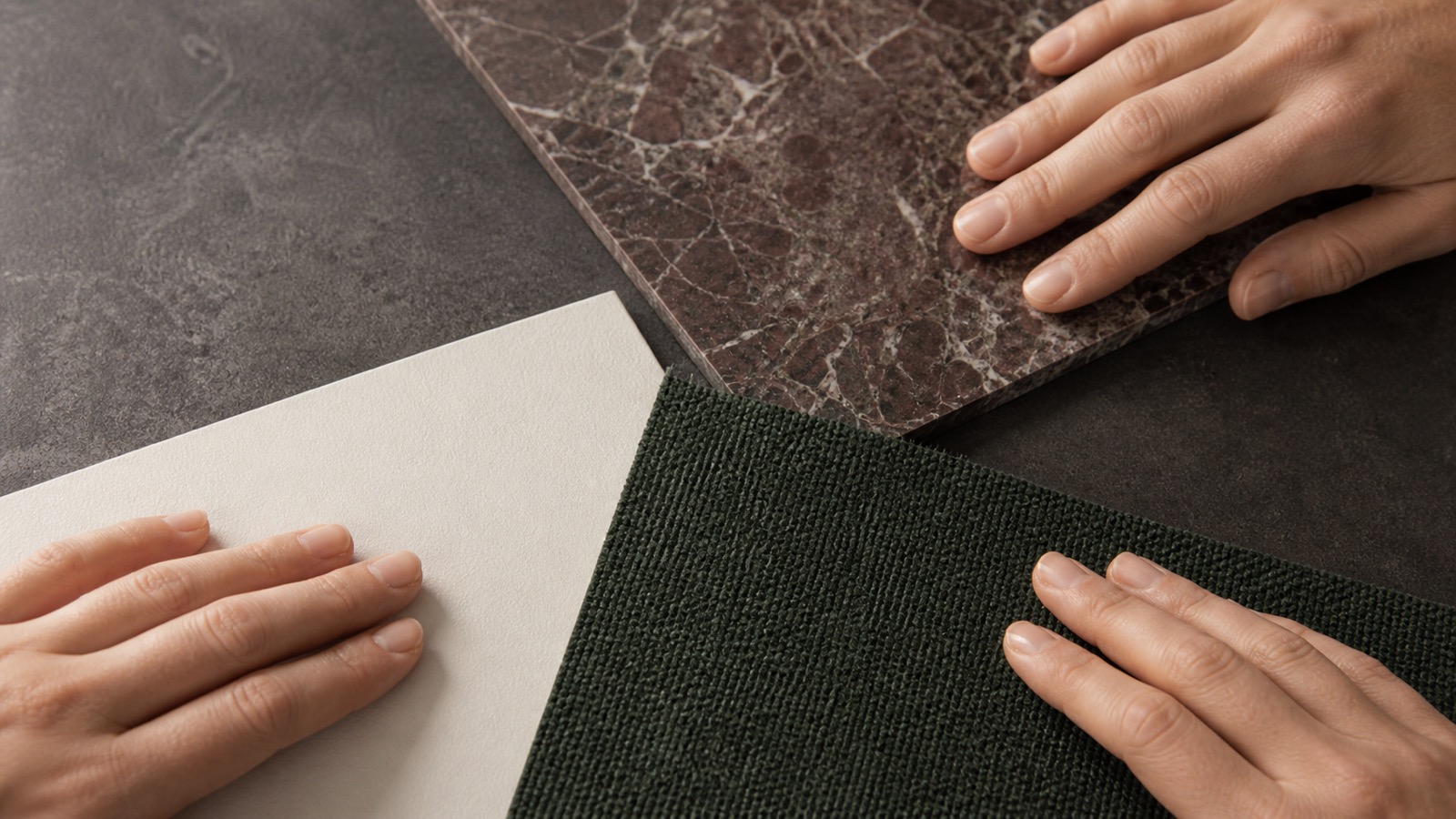 Mani che confrontano tre superfici anonime con luce neutra e texture chiaramente visibili in primo piano.
