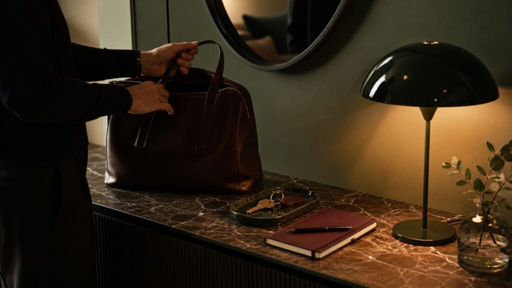 Preparazione serale su una consolle con borsa chiusa, chiavi, agenda e una nota con la prima azione del mattino.