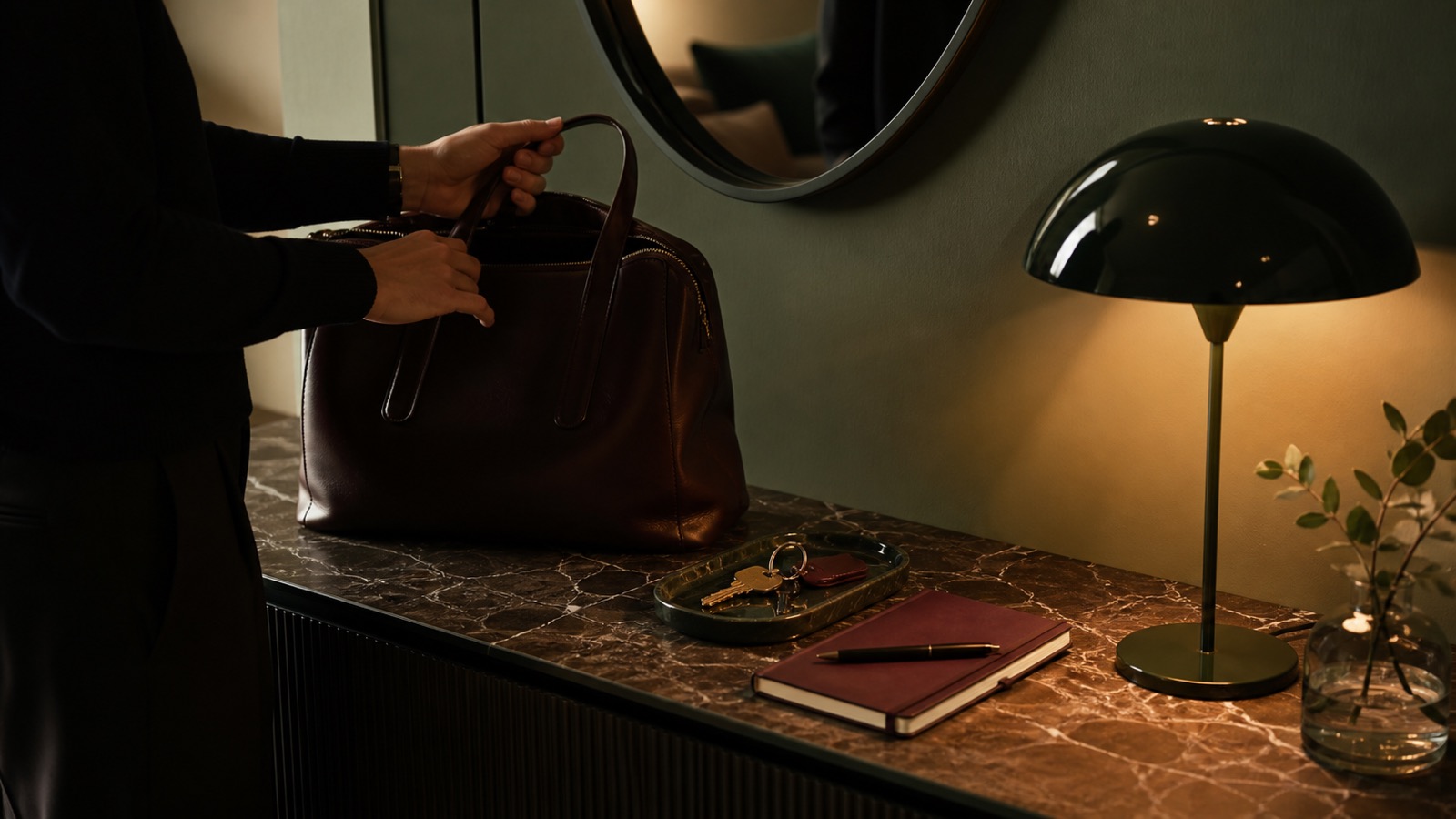 Preparazione serale su una consolle con borsa chiusa, chiavi, agenda e una nota con la prima azione del mattino.